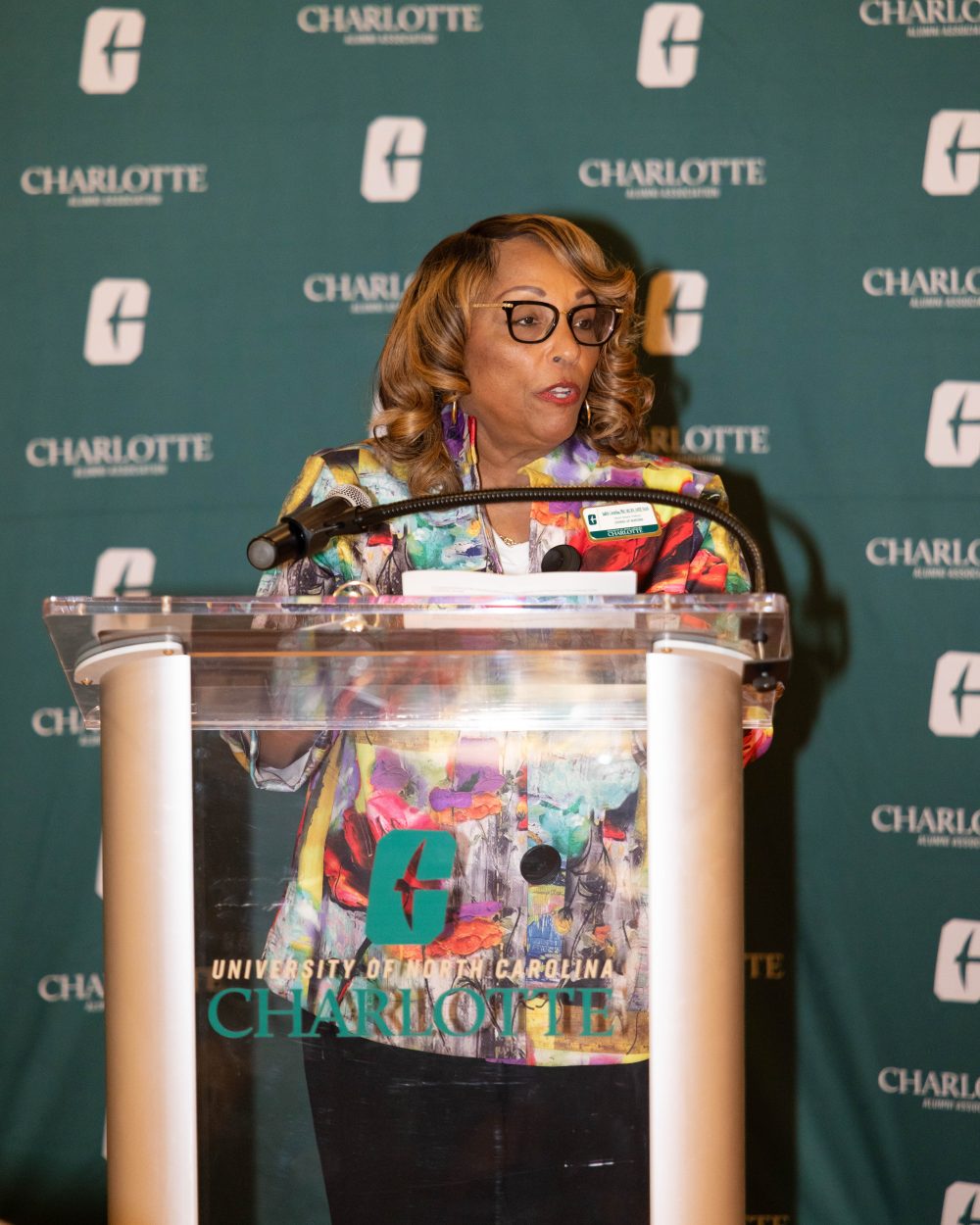 Dr. Judith Cornelius, Interim Director of the School of Nursing, stands at a podium speaking at an event hosted by the University of North Carolina Charlotte Alumni Association.